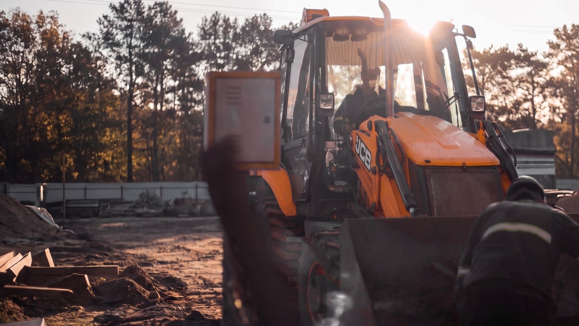 Retroescavadeira JCB da Brava Locações em obra ao entardecer